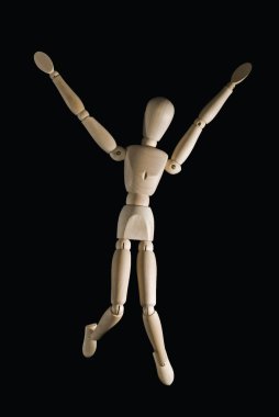 Wooden figure with a black back ground jumping out of joy clipart