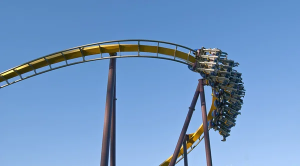 Roller coaster in beweging met blauwe hemel in de achtergrond — Stockfoto