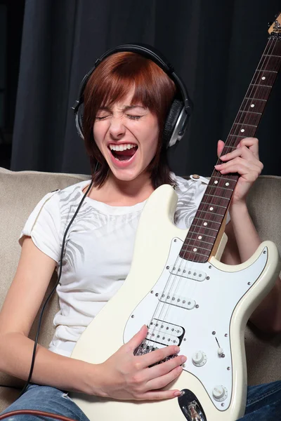 Mladá žena hraje na elektrickou kytaru — Stock fotografie