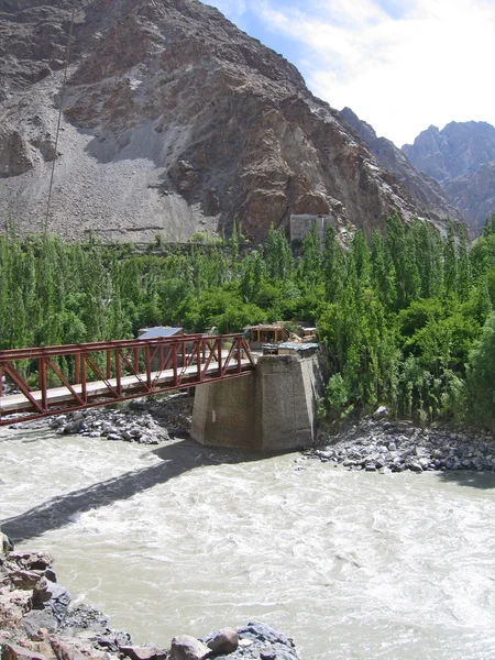 De brug door de rivier ind, in de bergen van ladakh, india. — Stockfoto