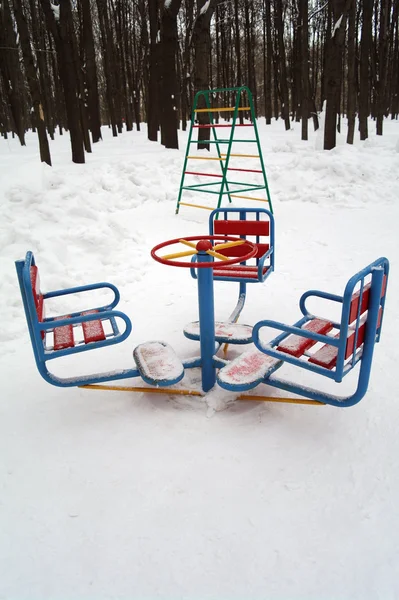 La rotonda infantil en invierno contra los árboles — Foto de Stock