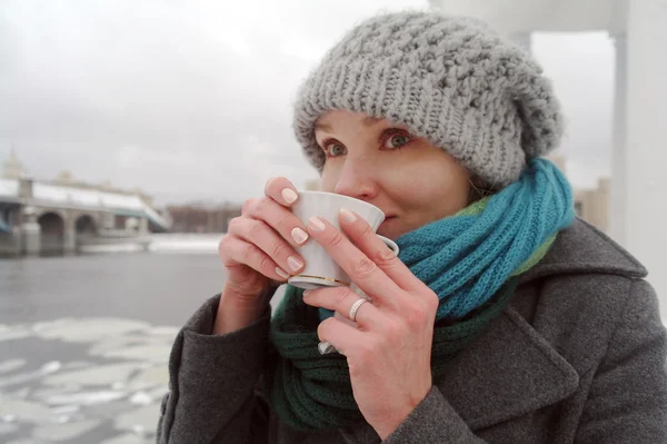 Genç Beyaz dondurulmuş kız sıcak çay kış aylarında içecekler. — Stok fotoğraf