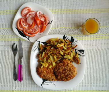 bir patates, domates salatası, bir bardak meyve suyu ile kızarmış et