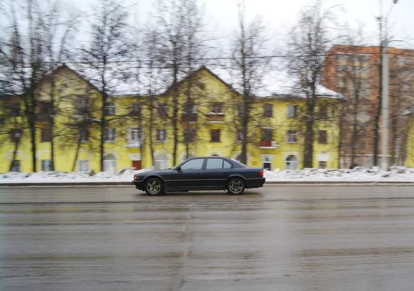 Araba sarı evin arka planda yolda gidiyor — Stok fotoğraf
