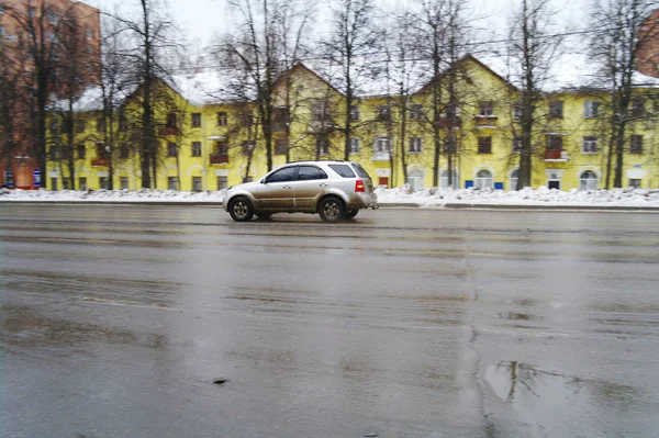 L'auto va sulla strada per uno sfondo della casa gialla — Foto Stock