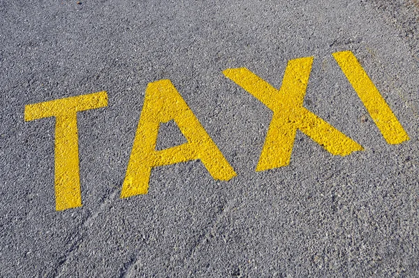 Una señal de parada de taxis pintada en la calle —  Fotos de Stock