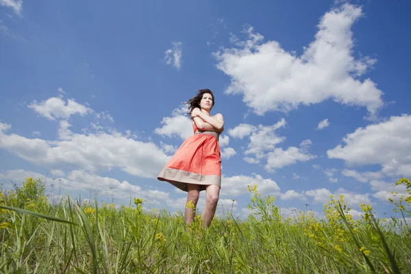 Beautiful young woman standing on field enjoying wind — Stock Photo, Image