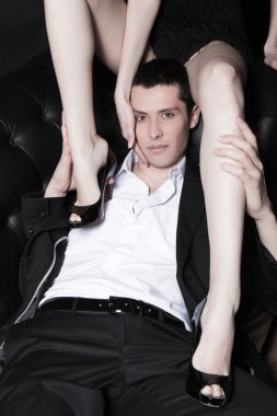 Portrait of attractive young man embracing womans perfect legs clipart