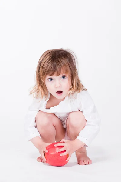 Bonito criança agachamento segurando maçã vermelha — Fotografia de Stock