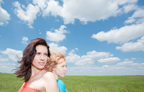 Två vackra unga kvinnor står på sommaren sätter — Stockfoto