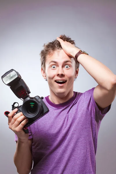Захоплений здивований фотограф з фотоапаратом під рукою — стокове фото