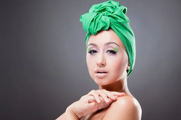 Заманчивая женщина с зеленым шарфом на голове и розово-зеленым макияжем — стоковое фото