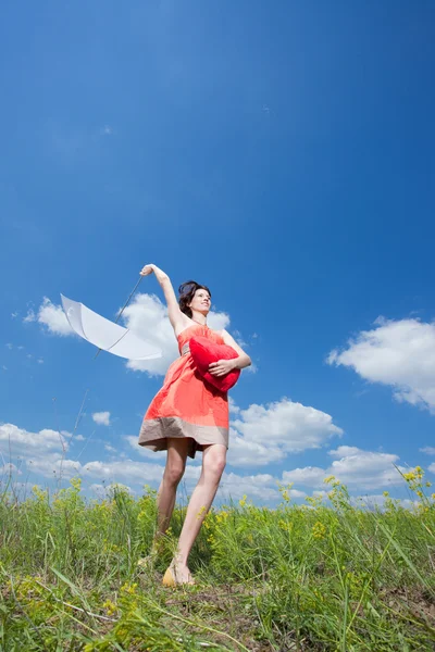 Mulher morena feliz ao ar livre com coração vermelho e guarda-chuva branco — Fotografia de Stock