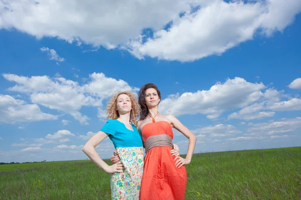 Two confident brunette and blonde women standing on field — Stock Photo, Image