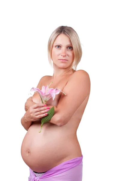 Ciąży szczęśliwy blond kobieta trzyma jej brzuch i lilia kwiat — Zdjęcie stockowe