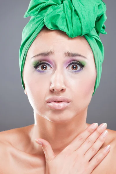 Wanita ketakutan dengan syal hijau di kepala dan merah muda-hijau cerah — Stok Foto