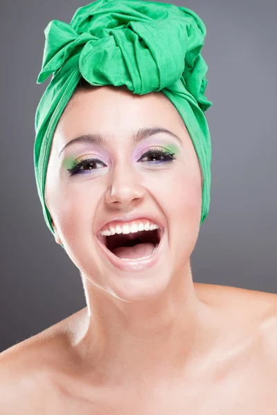 Счастливая улыбающаяся женщина с зеленым шарфом на голове — стоковое фото