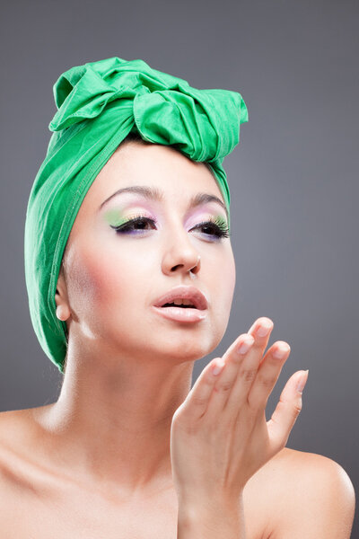 Sexy pin-up woman with green scarf on head sending kiss