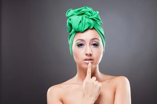 Schöne Pin-up-Frau mit grünem Schal zeigt auf ihre Lippen — Stockfoto