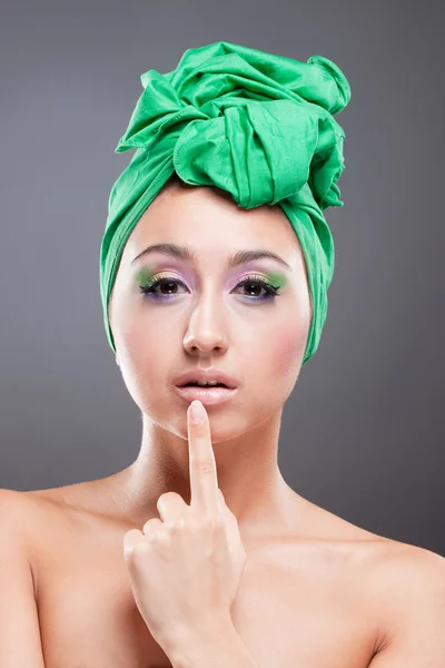 Beautiful pin-up woman with green scarf point at her lips — Stock Photo, Image