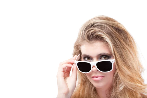 Vacker blond kvinna kika ut från under solglasögon — Stockfoto