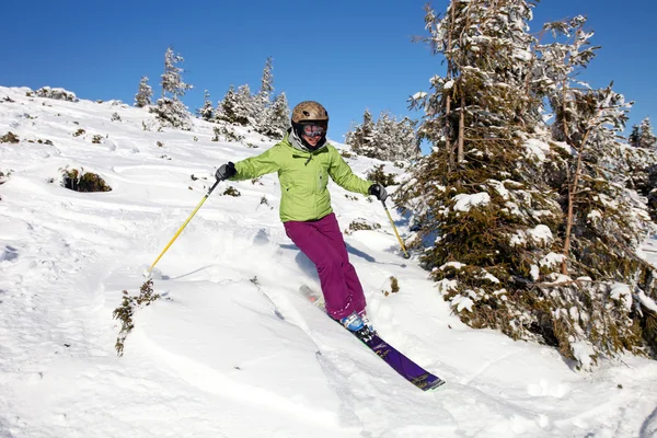 Female skier descending the hill — Stok fotoğraf
