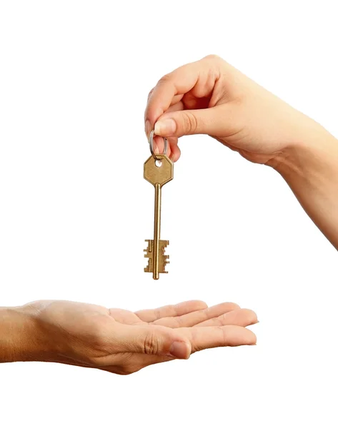 Schlüsselübergabe. weibliche Hand hält einen Schlüssel und übergibt ihn einer anderen Frau — Stockfoto
