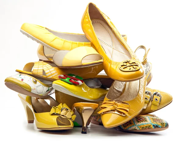 Mucchio di scarpe gialle femminili isolato su sfondo bianco — Foto Stock