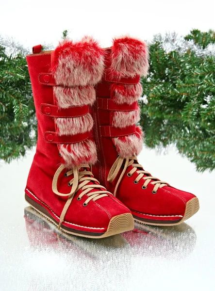 Pair of red female boots in winter decorating — Stock Photo, Image