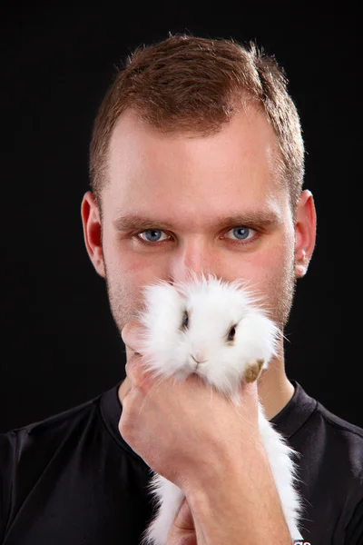 若い男と黒の背景に国内ウサギ — ストック写真
