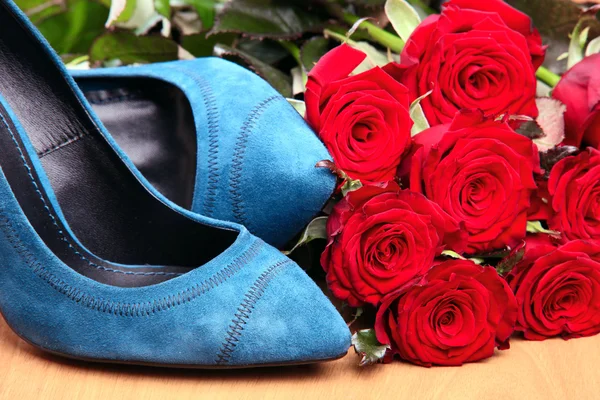 Fechar-se de par de sapatos femininos azuis e rosas vermelhas — Fotografia de Stock