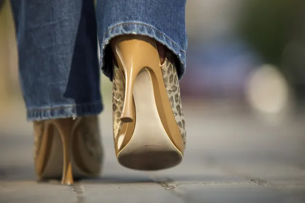 Close-up van vrouwelijke in jaguar gespot schoenen lopen — Stockfoto