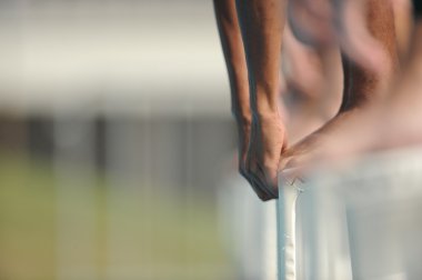 A male swimmer on the starting blocks clipart