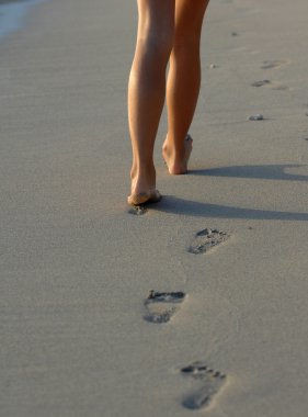 Kız sahilde yürüyor.