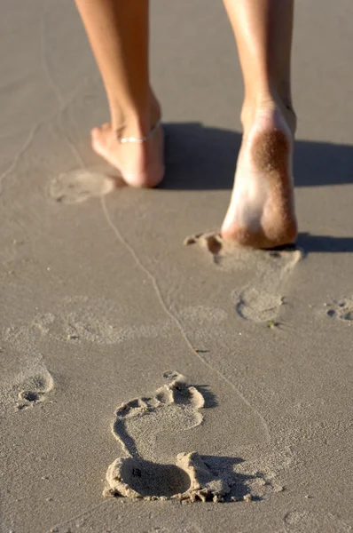 Ženské nohy na písečné pláži — Stock fotografie