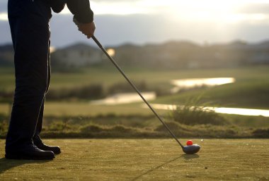 golfer tees off at putting green clipart