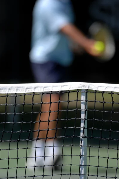 Tennisnetz mit defokussiertem Spieler — Stockfoto