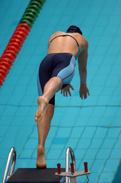 Жінка плаває, стрибаючи у воду — стокове фото