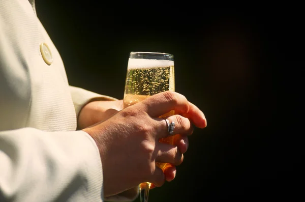 Handen met glas champagne — Stockfoto