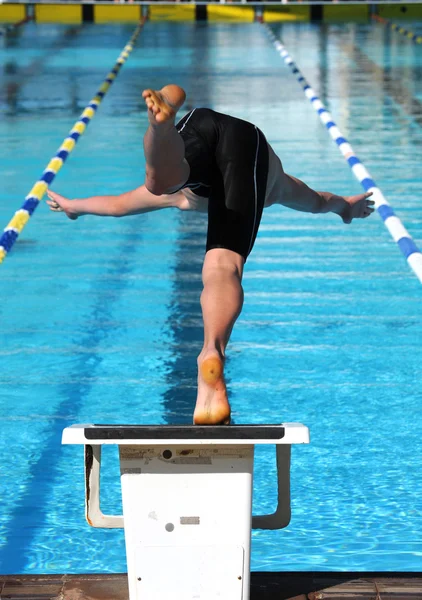 Le nageur plonge dans l'eau d'une piscine . — Photo