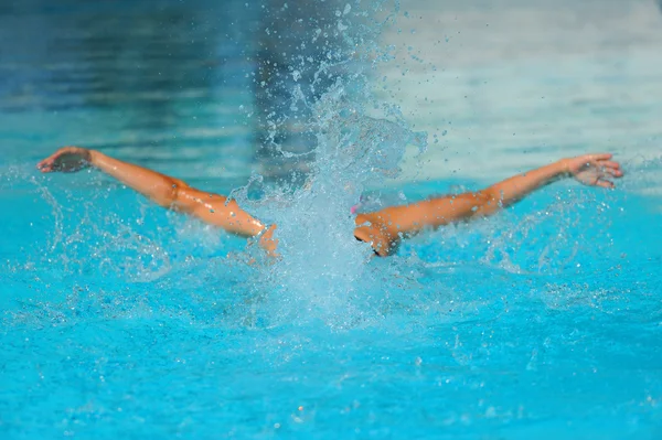 Nadador alimentando através da água de uma piscina — Fotografia de Stock