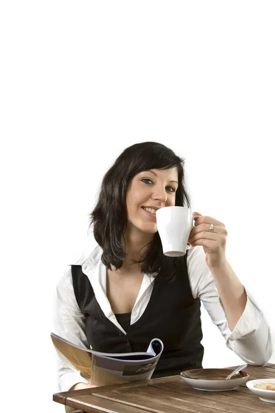 Donna che beve caffè e legge rivista Foto Stock