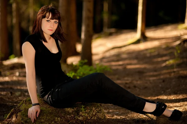 Siyah giysiler ormanda oturan genç kız — Stok fotoğraf