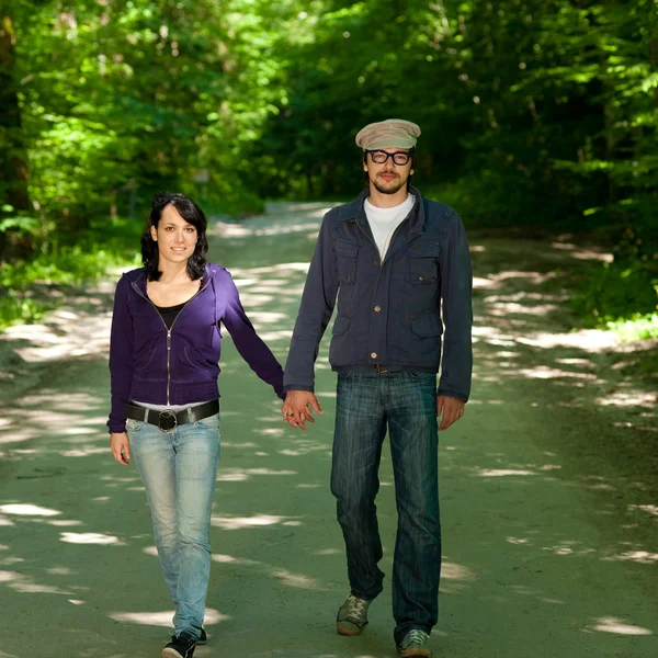 Young couple walking through forest — Stock Photo, Image