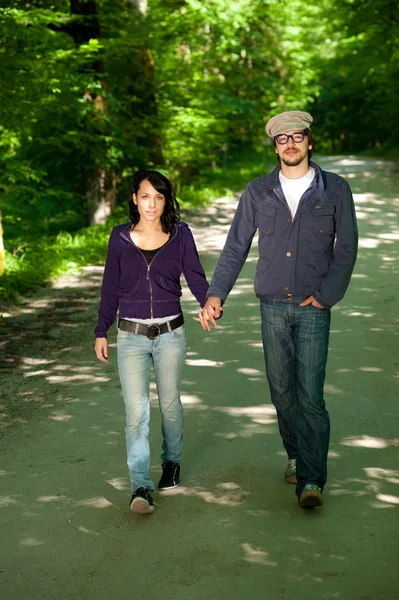 Young couple wolking through forest — Stock Photo, Image