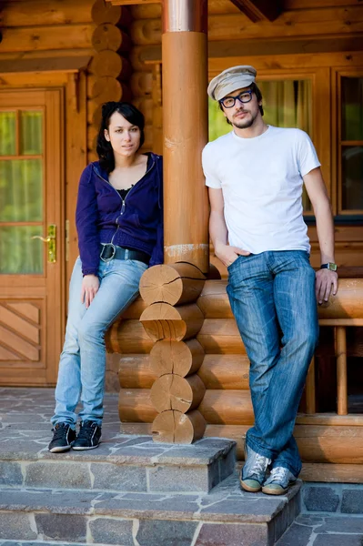 木房子前对年轻夫妇 — 图库照片
