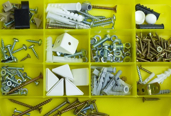 Parte da caixa de ferramentas amarela com parafusos e cavilhas — Fotografia de Stock