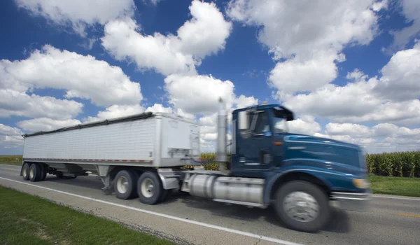 Wazig semi-vrachtwagen onder gek wolken — Stockfoto