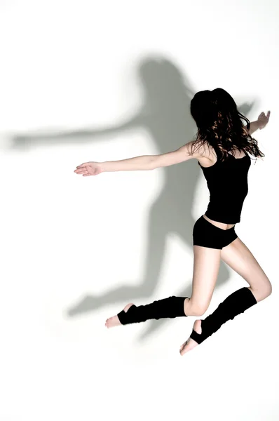 stock image Gymnast jumping in studio with hard light