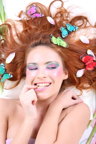 年轻的红发女子与蝴蝶和花瓣 — 图库照片